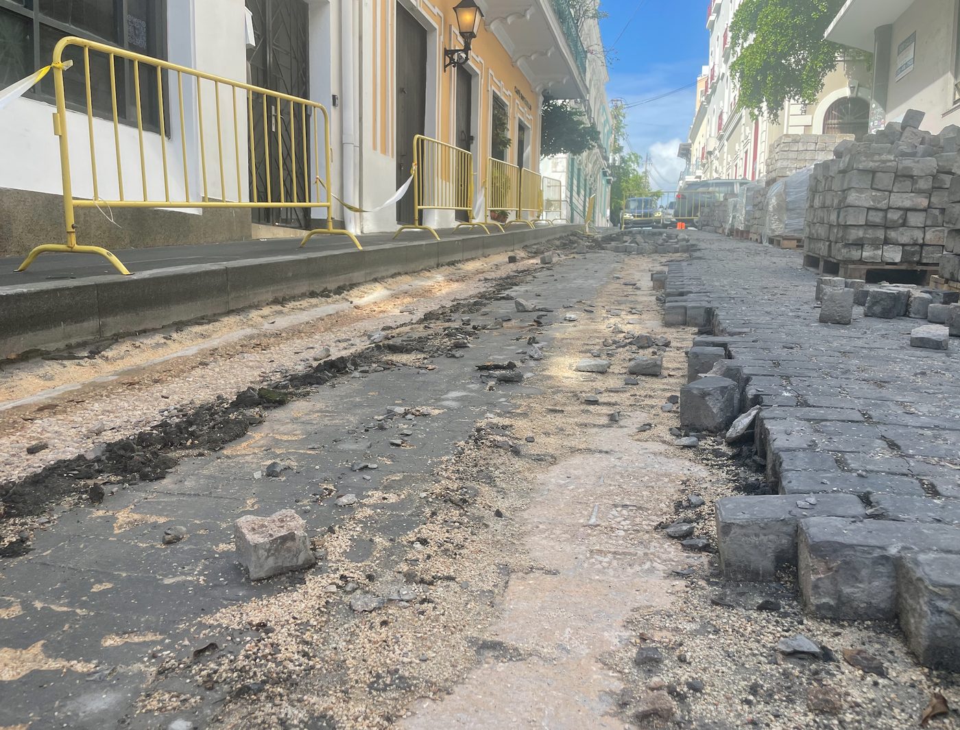 Calle del casco histórico con los adoquines levantados durante trabajos de reconstrucción, con pilas de adoquines a un lado